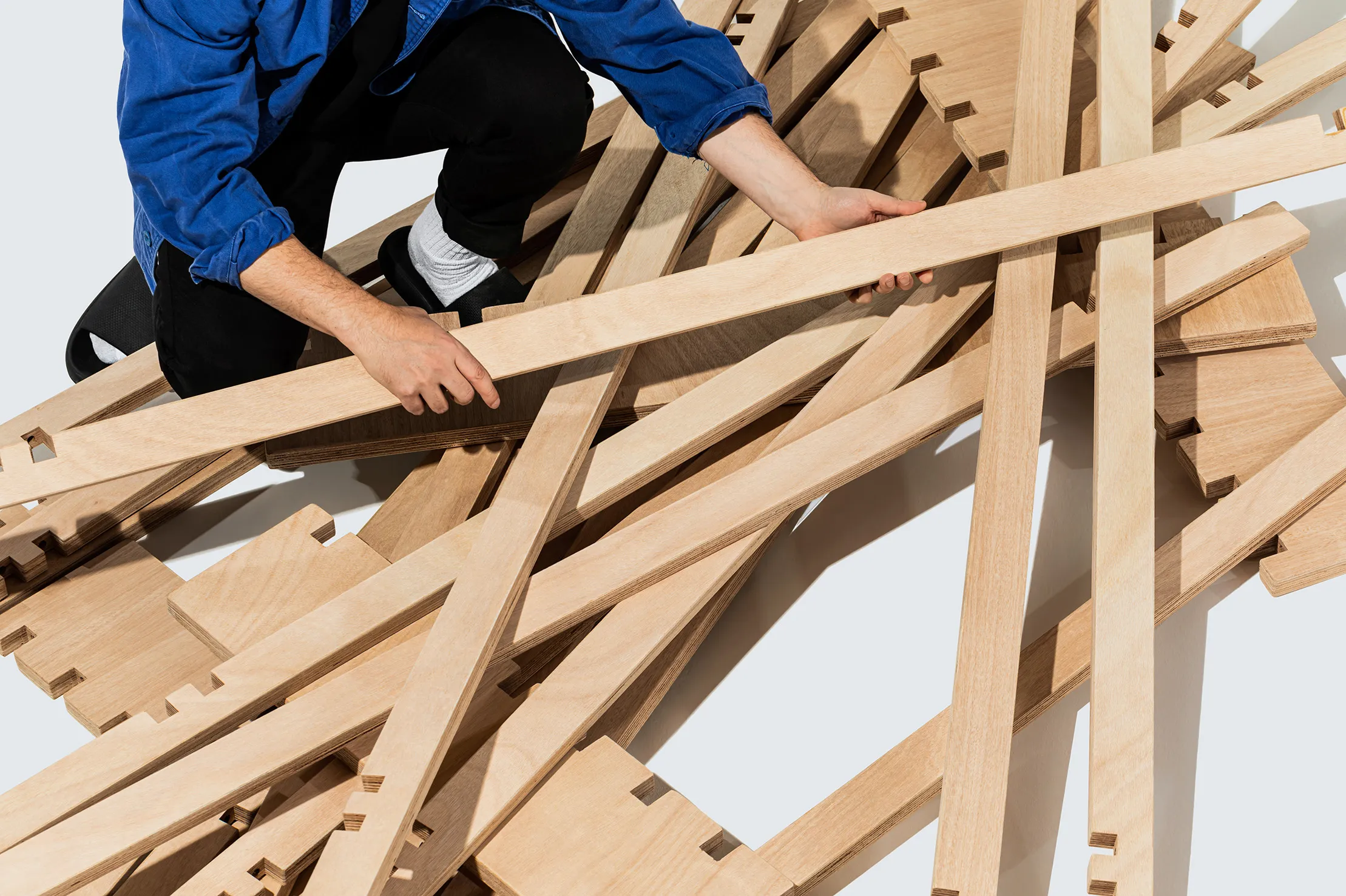 A person building the Tic Tac Toe bed by Quagga Designs.