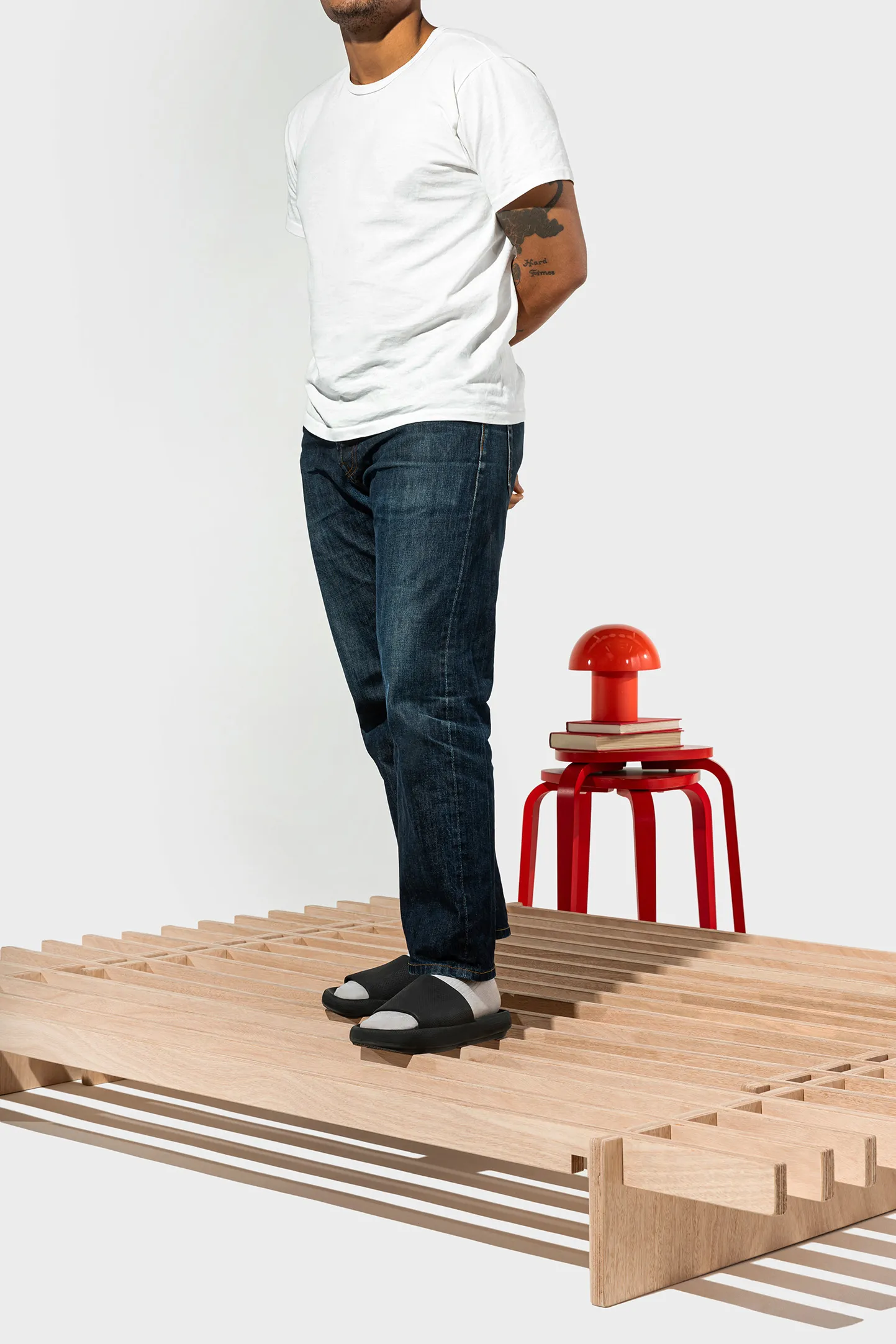 A person standing on the No Fuss Plus bed frame by Quagga Designs.