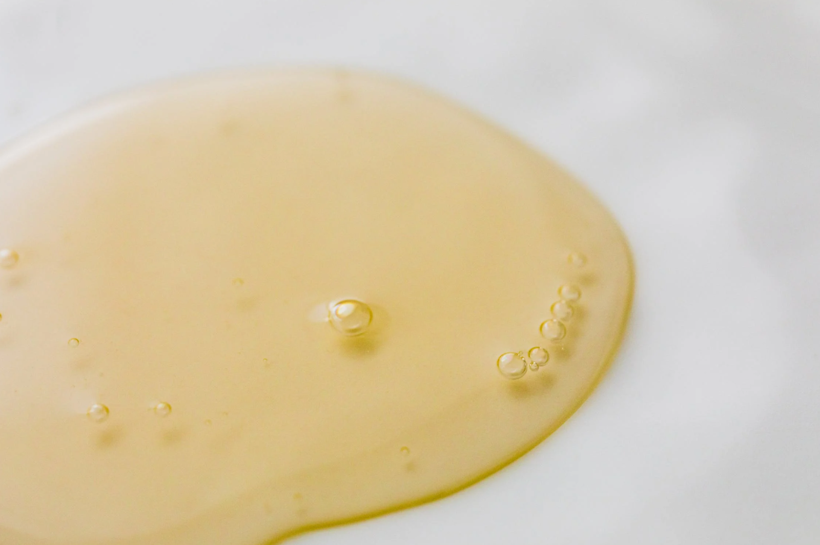 Clear yellow liquid on a flat white surface.
