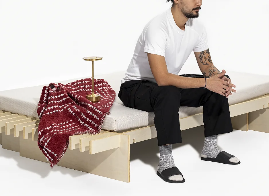 A person sitting on the No Fuss Plus bed frame by Quagga Designs.